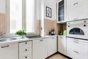 una cocina blanca con armarios blancos y fregadero en BDC - The Choice, your 2-Bdr apt in Vatican district, en Roma