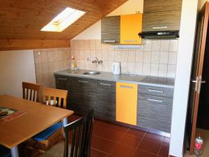 eine Küche mit Spüle und Tisch mit Stühlen in der Unterkunft Gumla House in Stara Novalja