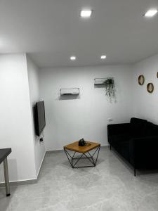 a living room with a black couch and a table at מישל נופש ,צופית תחתית 6003 in Eilat