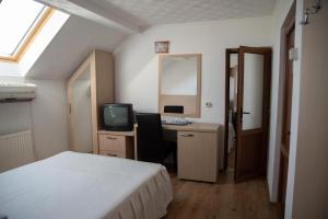 une chambre avec un lit et un bureau avec un ordinateur dans l'établissement Motel Moara Veche, à Săcălăşeni