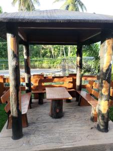 a wooden pavilion with benches and tables in a park at JLF Inn in Daraga