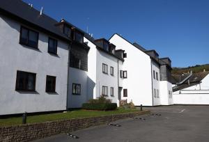 a row of white buildings with a parking lot at Starfish Apartment in Beer