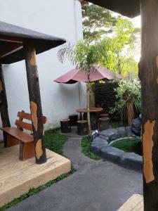 a patio with a bench and a table and an umbrella at JLF Inn in Daraga