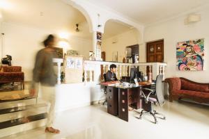 un homme assis à un bureau avec un ordinateur dans une pièce dans l'établissement Tranquilo Arambol, à Arambol