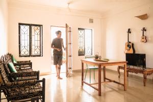 a man standing in a living room with a table at Tranquilo Arambol in Arambol