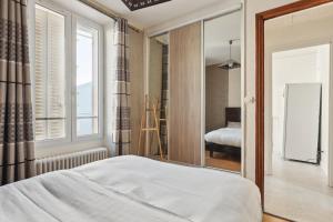 a bedroom with a bed and a large mirror at Le Gambetta in Saint-Cyr-lʼÉcole