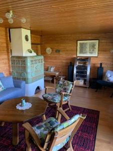 uma sala de estar com um sofá, uma mesa e um fogão em Ferienhaus Summerer em Grafenau