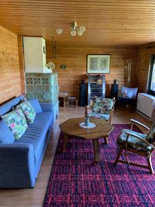 uma sala de estar com um sofá azul e uma mesa em Ferienhaus Summerer em Grafenau