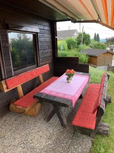 un tavolo da picnic e 2 panche su un patio di Ferienhaus Summerer a Grafenau
