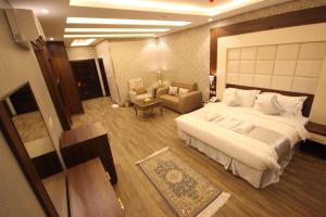 una habitación de hotel con una cama grande y una silla en Suit los, en Az̧ Z̧afīr
