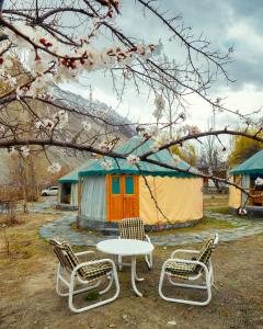 grupa krzeseł, stół i namiot w obiekcie Roomy Yurts, Gulmit Hunza w mieście Gulmit