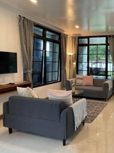 - un salon avec deux canapés et une télévision dans l'établissement Hidden Hill Villa Kota Bunga by Citrus House, à Cipanas