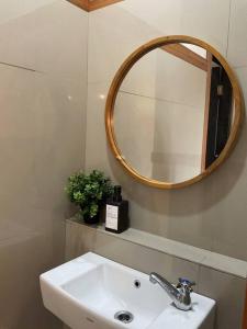 La salle de bains est pourvue d'un lavabo et d'un miroir. dans l'établissement Hidden Hill Villa Kota Bunga by Citrus House, à Cipanas