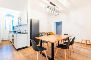 a kitchen and dining room with a wooden table and chairs at Alloro Apartment in Florence