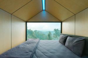 En eller flere senge i et værelse på Bobocabin Coban Rondo, Malang