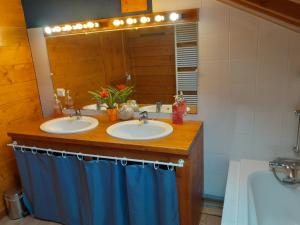 a bathroom with two sinks and a mirror and a tub at Chambre d'Hôtes Barnabas in Saint-Martin-de-la-Porte