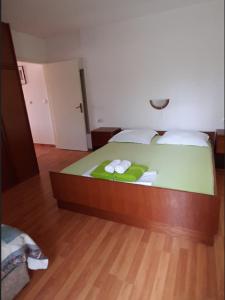 1 dormitorio con 1 cama con 2 toallas en Apartments Snjezana, en Rab