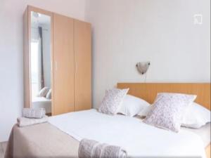 1 dormitorio con 2 camas y espejo en Apartments Snjezana, en Rab