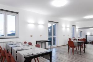 a dining room with tables and chairs and windows at Looky Hotel in Sori