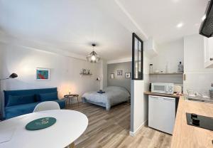 un soggiorno con un divano blu e un letto di Le Mimont - Hyper Centre - Lumineux - Spacieux a Cannes