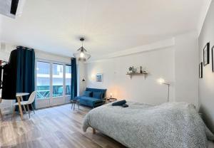 una camera da letto con un letto e un divano blu di Le Mimont - Hyper Centre - Lumineux - Spacieux a Cannes