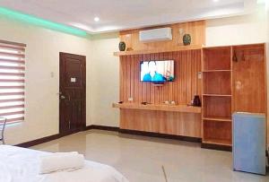 um quarto com uma televisão e uma cama num quarto em RedDoorz @ Sundance Mountain Resort Tampilisan em Zamboanga