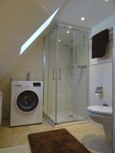 a bathroom with a shower and a washing machine at New Business Apartment with Flair in Hersbruck