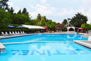 una piscina in un resort con sedie e alberi di Çetinel Otel a Adana