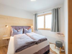 Haus Heimat - Enzian : غرفة نوم بسرير كبير ونافذة