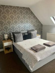 Un dormitorio con una cama grande y una pared en Gillygate Holiday Apartment, en York