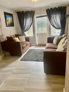 una sala de estar con 2 sofás y una alfombra en Gillygate Holiday Apartment, en York