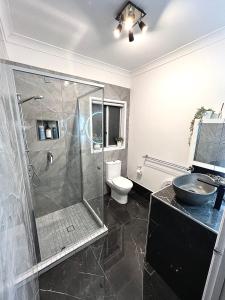 een badkamer met een douche, een toilet en een wastafel bij Berghofen in Mount Tamborine