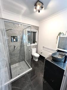 a bathroom with a shower and a toilet and a sink at Berghofen in Mount Tamborine