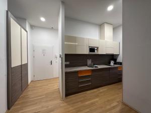 a kitchen with white cabinets and a wooden floor at Vienna City Apartment 7 in Vienna
