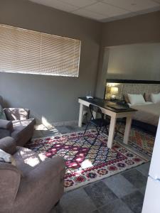 a living room with a table and a bed at Tucked-Away 1,2,3,bedroom houses in Nelspruit