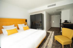 1 dormitorio con 1 cama grande y 1 silla amarilla en Le Barracuda & Spa, Centre Port, pieds dans l'eau, vue mer en Brest
