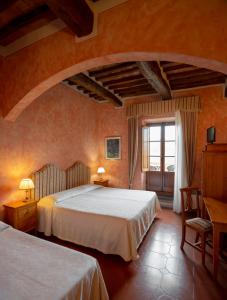1 dormitorio con 2 camas y ventana en B&B Palazzo Al Torrione 2, en San Gimignano
