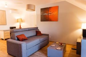 a living room with a couch and a table at Studio confortable, parking et jardin in Buchères