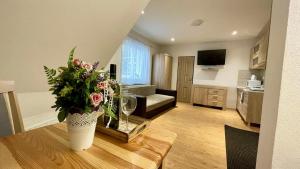 a living room with a vase of flowers on a table at Ubytovanie Athéna in Poprad