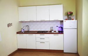 a kitchen with white cabinets and a white refrigerator at Residence Torre Saracena in Villapiana