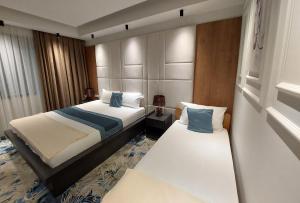 a hotel room with two beds and a window at Apartments Jordan Luxury in Gevgelija