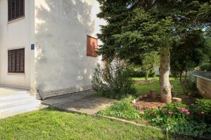 a house with a tree in the yard at Merlini in Medulin