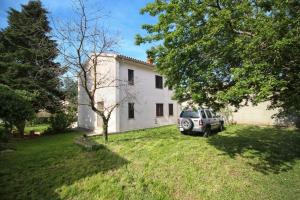 a car parked in front of a white house at Merlini in Medulin