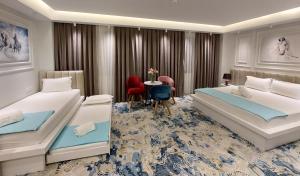 a hotel room with two beds and a table at Jordan Luxury in Gevgelija