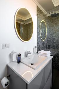 Baño blanco con lavabo y espejo en UBA Accommodation Aparthotel, en Cluj-Napoca
