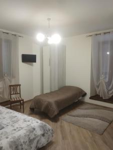 Casa porta San Francesco في Alatri: غرفة نوم بسرير وكرسي وتلفزيون