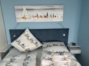 a bed with two pillows and a picture of boats at See-Lün in Westerland (Sylt)