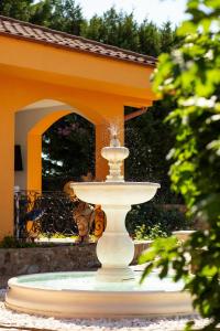 a fountain in the middle of a yard with a building at La Conac in Arad