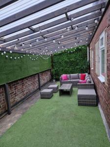 a patio with couches and chairs on a brick wall at Luxury Mirror Party Pad with 4 Bedrooms! Silent Disco Package included in Liverpool