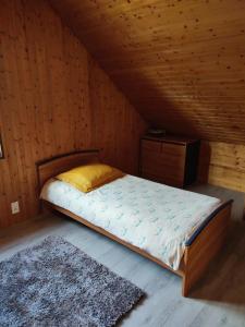 - un lit dans une chambre en bois avec un tapis dans l'établissement Chambre d'hôtes à la campagne "Le coudry", à Serley